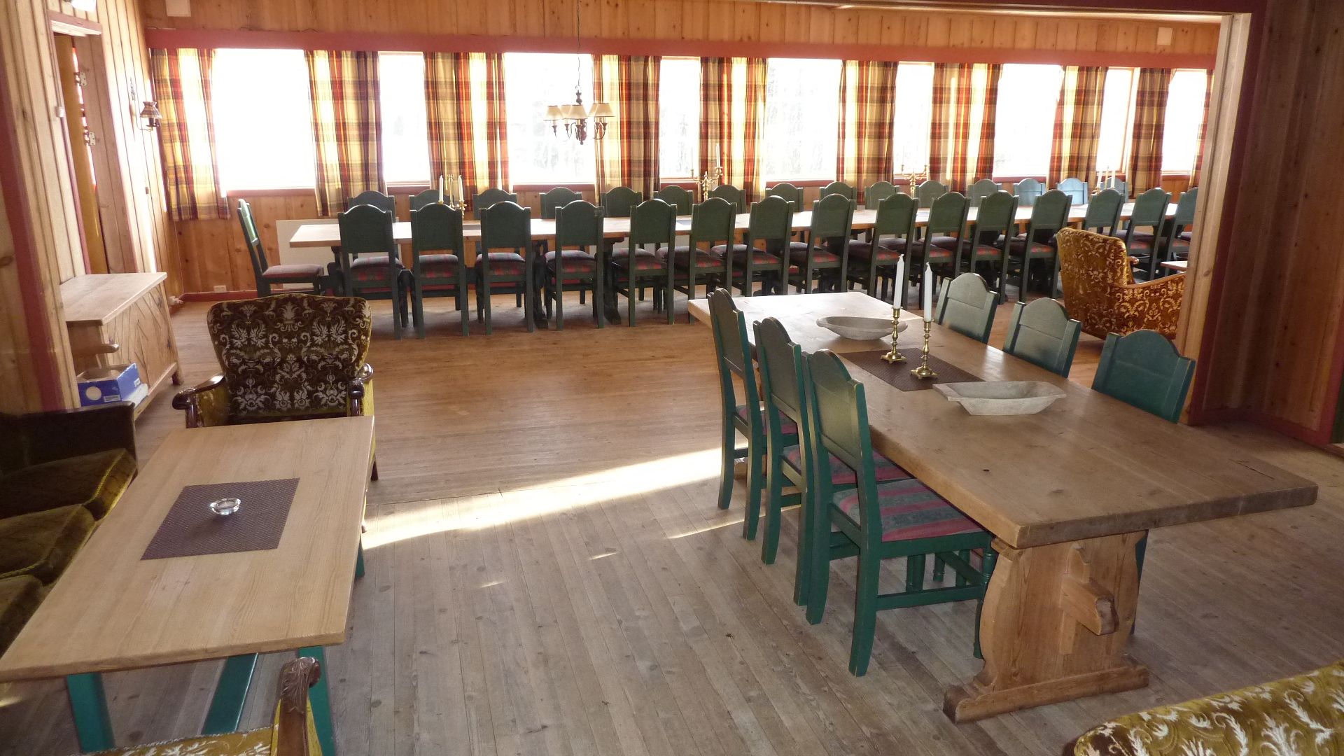 Peisstue med langbord og spisestue i bakgrunnen Spisestue langbord